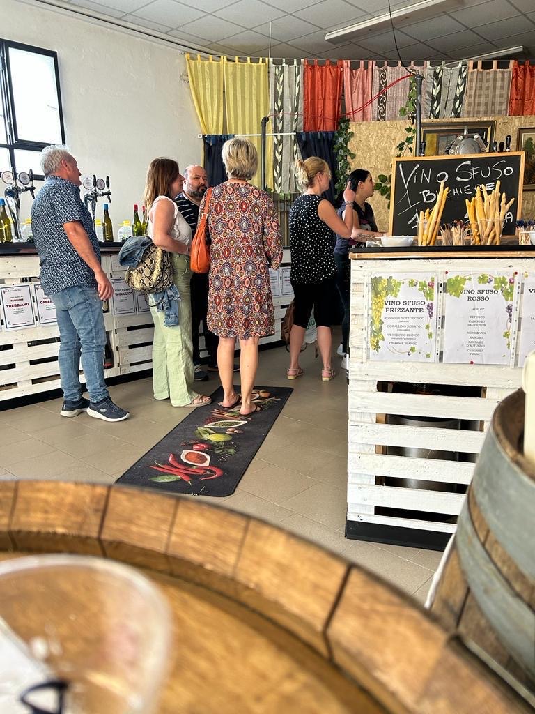 Clienti in visita alla Vineria Codigorese, tra vino sfuso e bottiglie